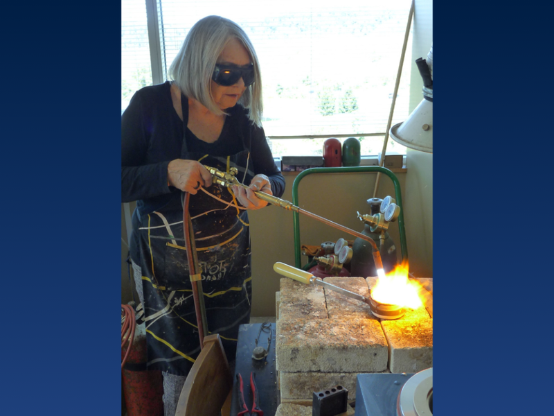 a woman wears goggles while welding