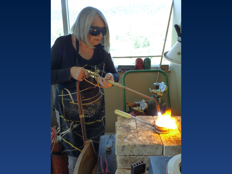 a woman wears goggles while welding